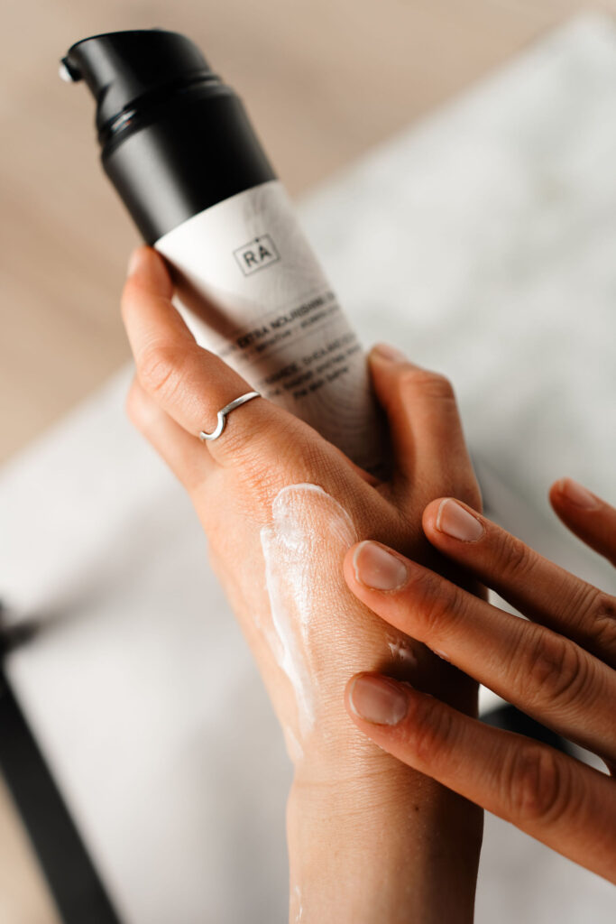 kvinne smører hendene med rå skincare favn extra nourishing cream