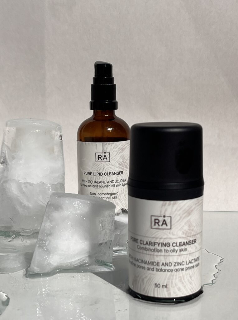 Pure Lipid Cleanser and Pore Clarifying Cleanser from RÅ Skincare, presented together as a double cleanser on a light background with ice cubes for a fresh feeling.