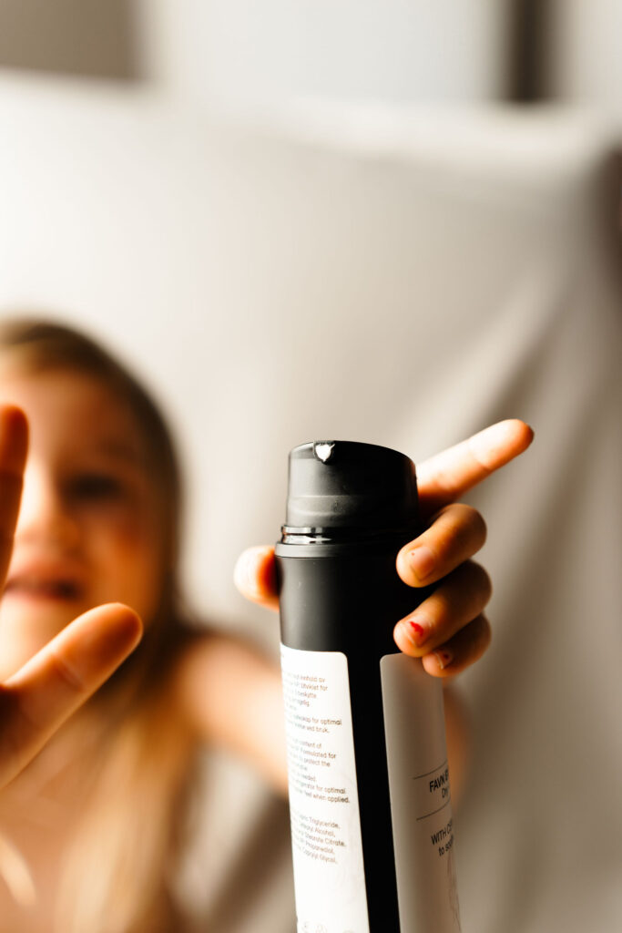 barn holder rå skincare krem i hånden.