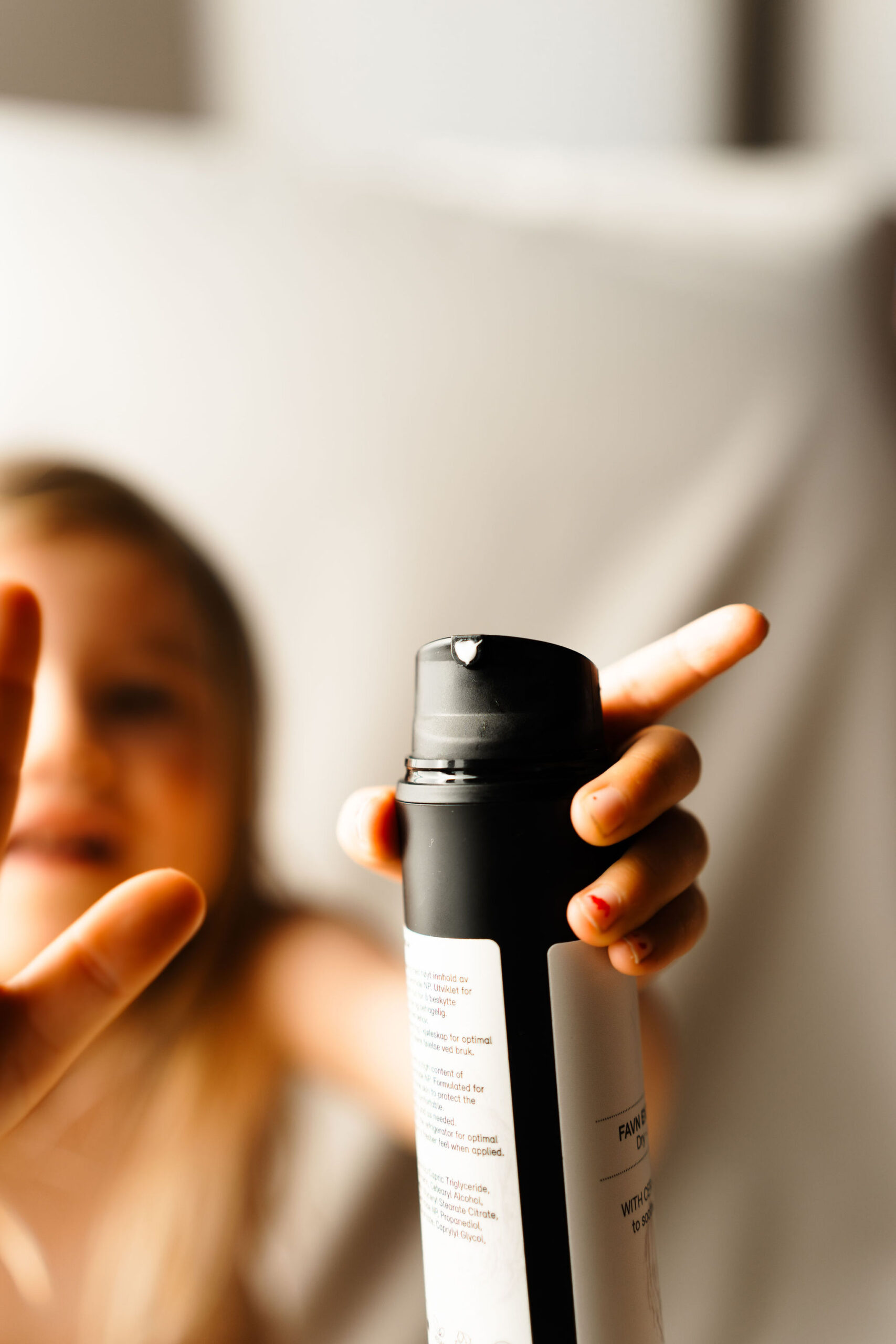 barn holder rå skincare krem i hånden.