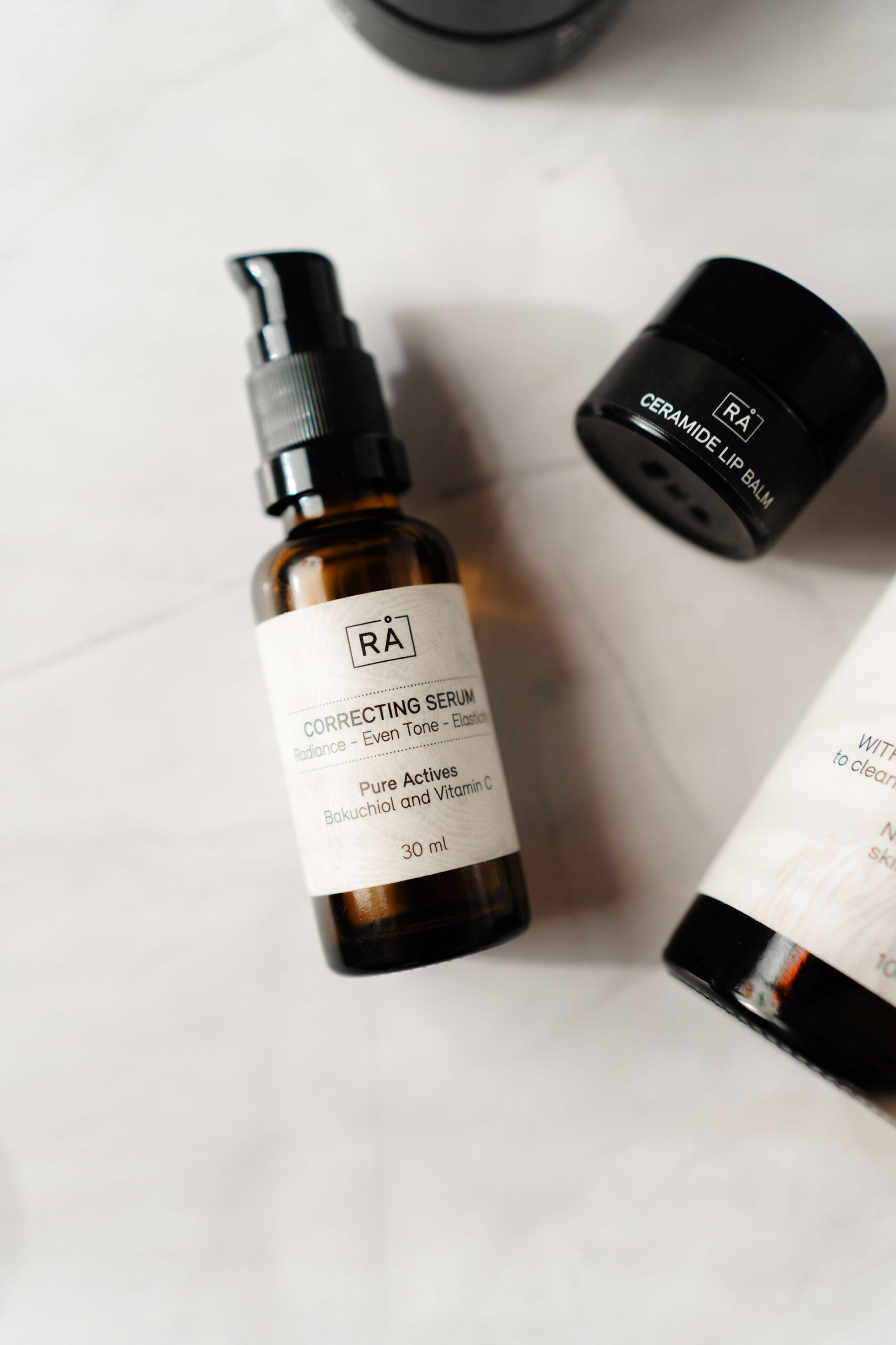 rå correcting serum ligger på lys bakgrunn sammen med ceramide lip balm og rens