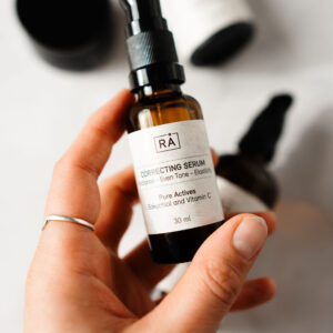 rå correcting serum holdes i hånden
