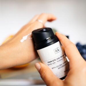 Favn Eye and Facial Cream fra RÅ Skincare påføres hånden for å vise kremens rike konsistens for tørr hud.