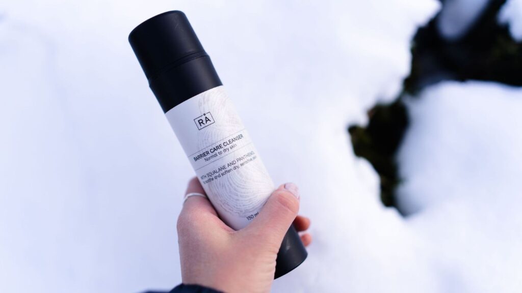 Barrier care cleanser holdes i hånden ute med snø i bakgrunnen 