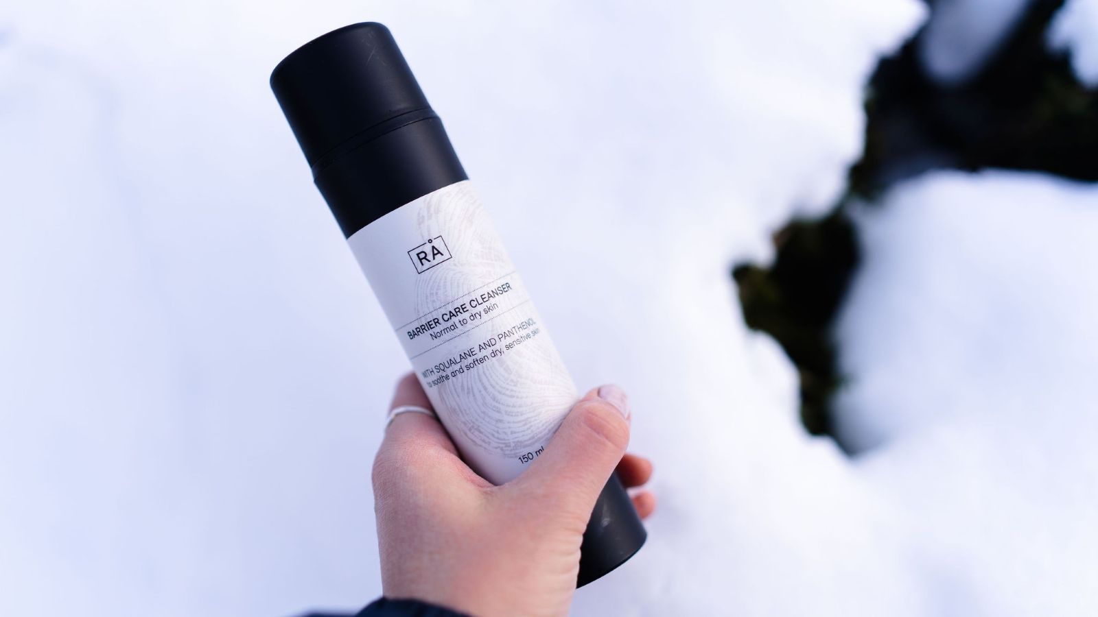 Barrier care cleanser holdes i hånden ute med snø i bakgrunnen