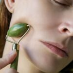 kvinne bruker ansiktsrulle på huden sin