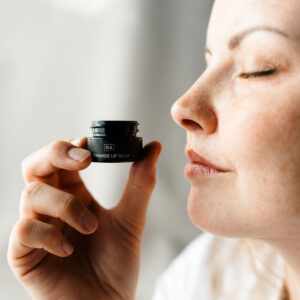 lip balmen holdes ved siden av leppene. nærbilde