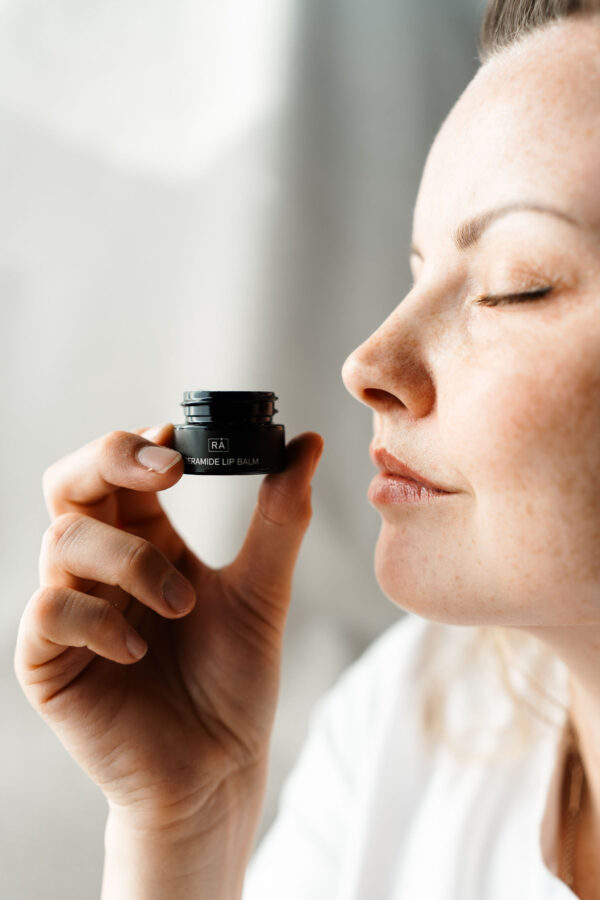 lip balmen holdes ved siden av leppene. nærbilde