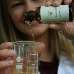Gründer heller jojoba oil over i labglass for å vise konsistens og farge på produktet