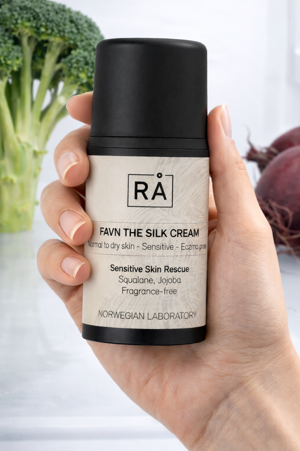 RÅ Skincare Favn the silk cream holdes i hånden inne i kjøleskap for å vise hvordan produktet skal oppbevares og få frem renhet.
