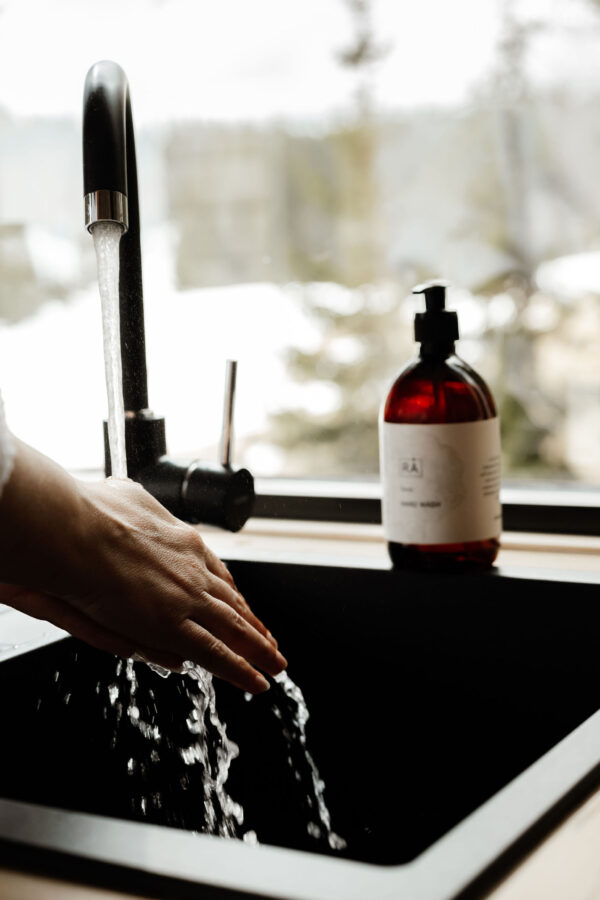 Hender vaskes med RÅ Skincare sevje håndsåpe på kjøkkenet på lauv tretopphytter.