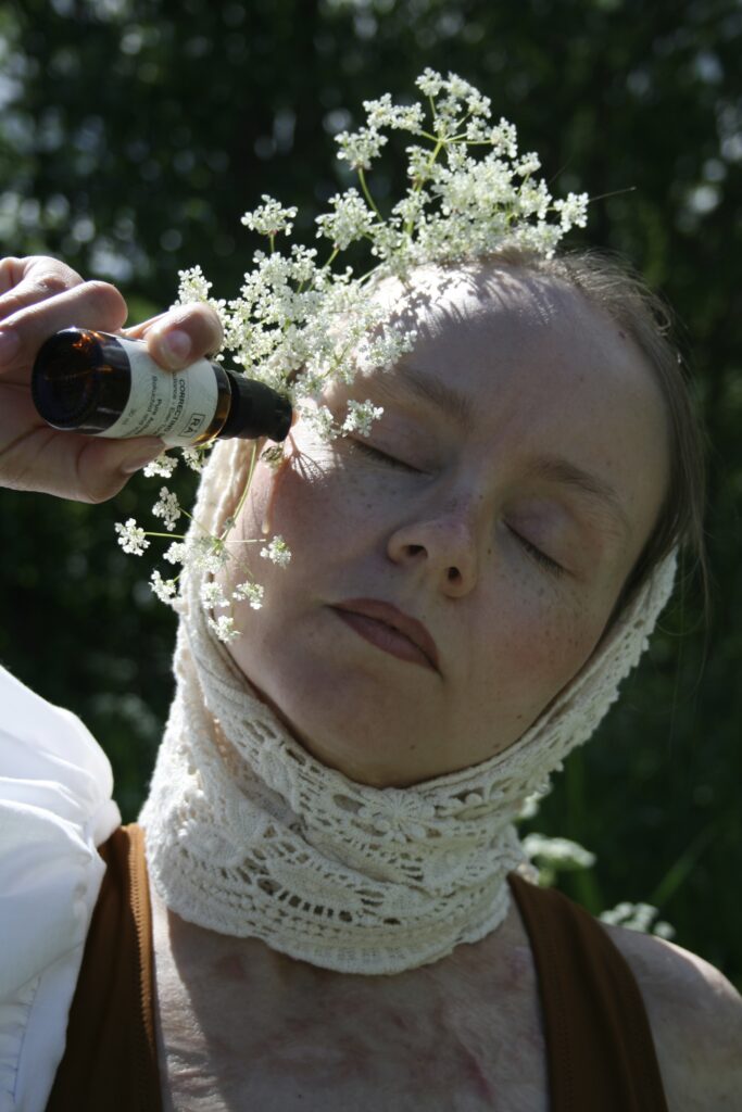 Tine Linnea med multi active serum ute i blomstereng