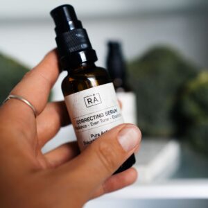 Correcting Serum fra RÅ Skincare med bakuchiol og vitamin C tas ut av kjøleskapet. I bakgrunnen ser du brokkoli inne i kjøleskapet. nærbilde.