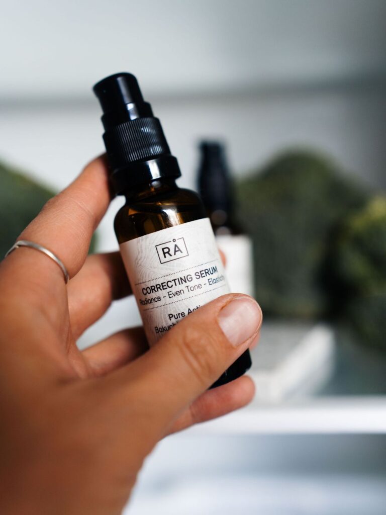 Correcting Serum from RÅ Skincare with bakuchiol and vitamin C is taken out of the refrigerator. In the background you can see broccoli inside the refrigerator. Close-up.