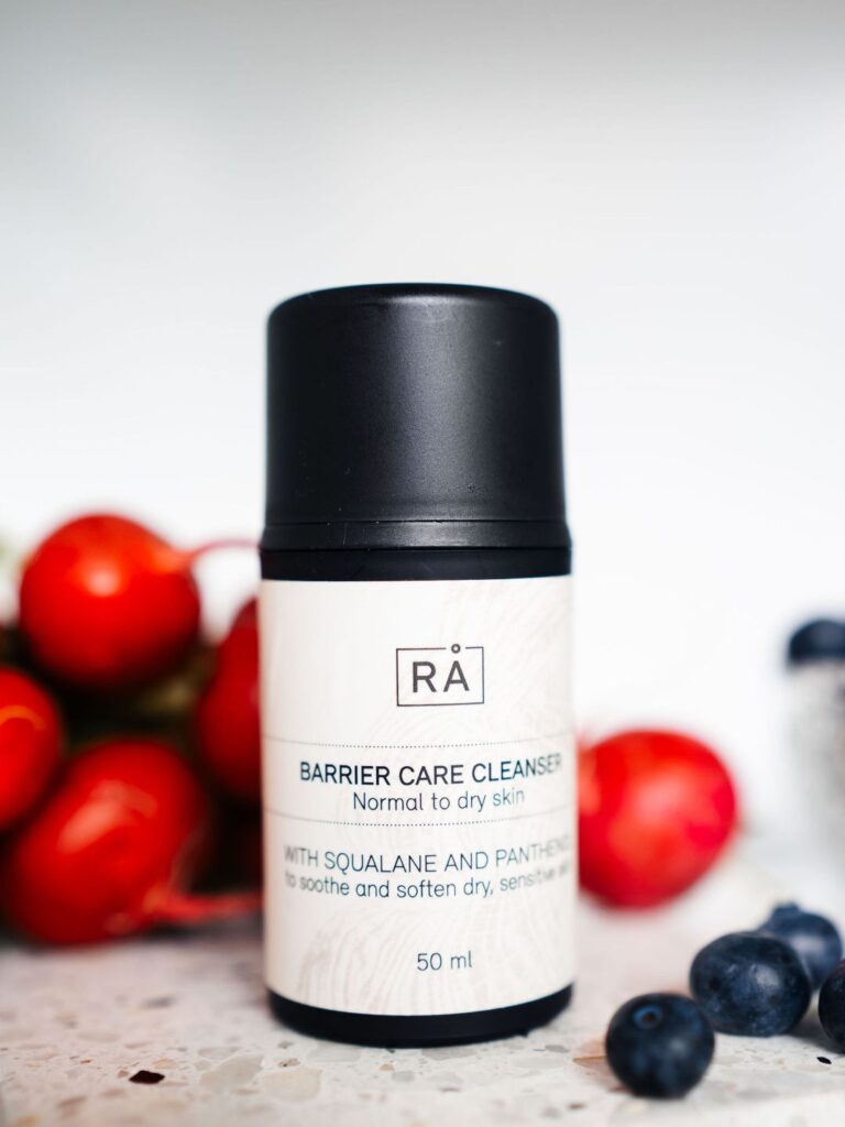 Barrier Care Cleanser 50 ml fra RÅ Skincare fotografert inni et kjøleskap med blåbær og røde reddiker i bakgrunnen