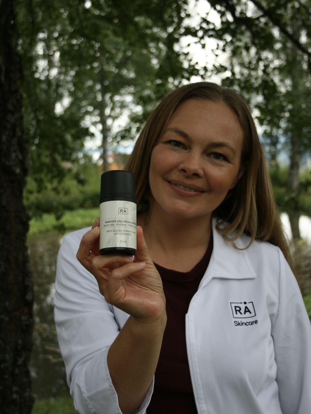 Amanda is one of the founders of RÅ. She stands in a white work uniform and holds a product to share her expert advice.